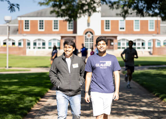 Students walking together in front of Arnold Bernhard library